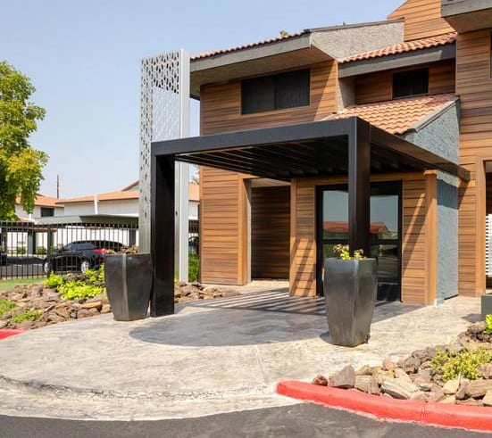 leasing building exterior with a wooden facade and a stone walkway