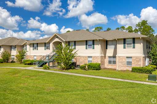 A row of houses with green lawns in front.