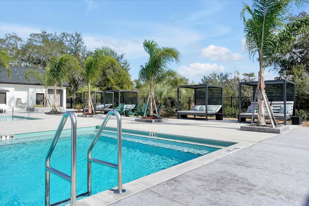 A pool surrounded by trees and benches.
