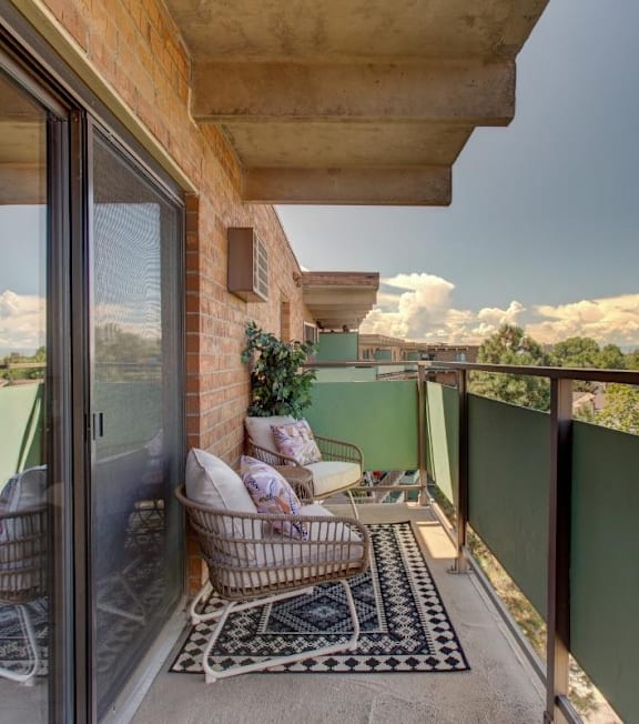 A balcony with a person sitting on a chair.