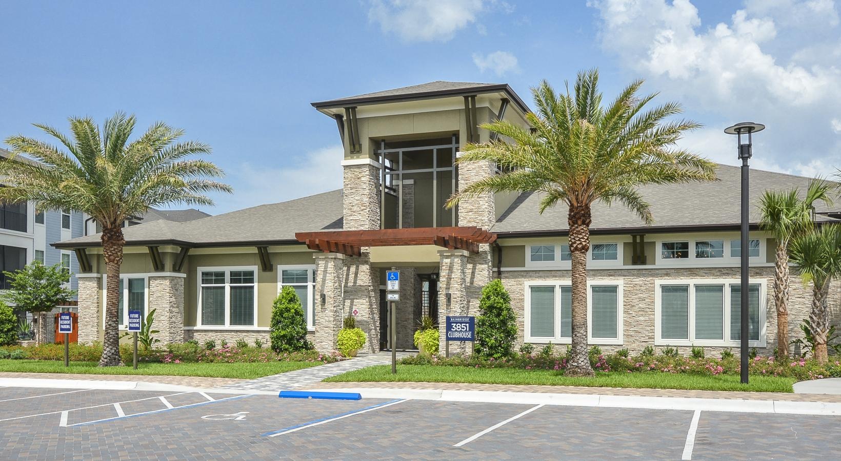 a building with palm trees and a parking lot