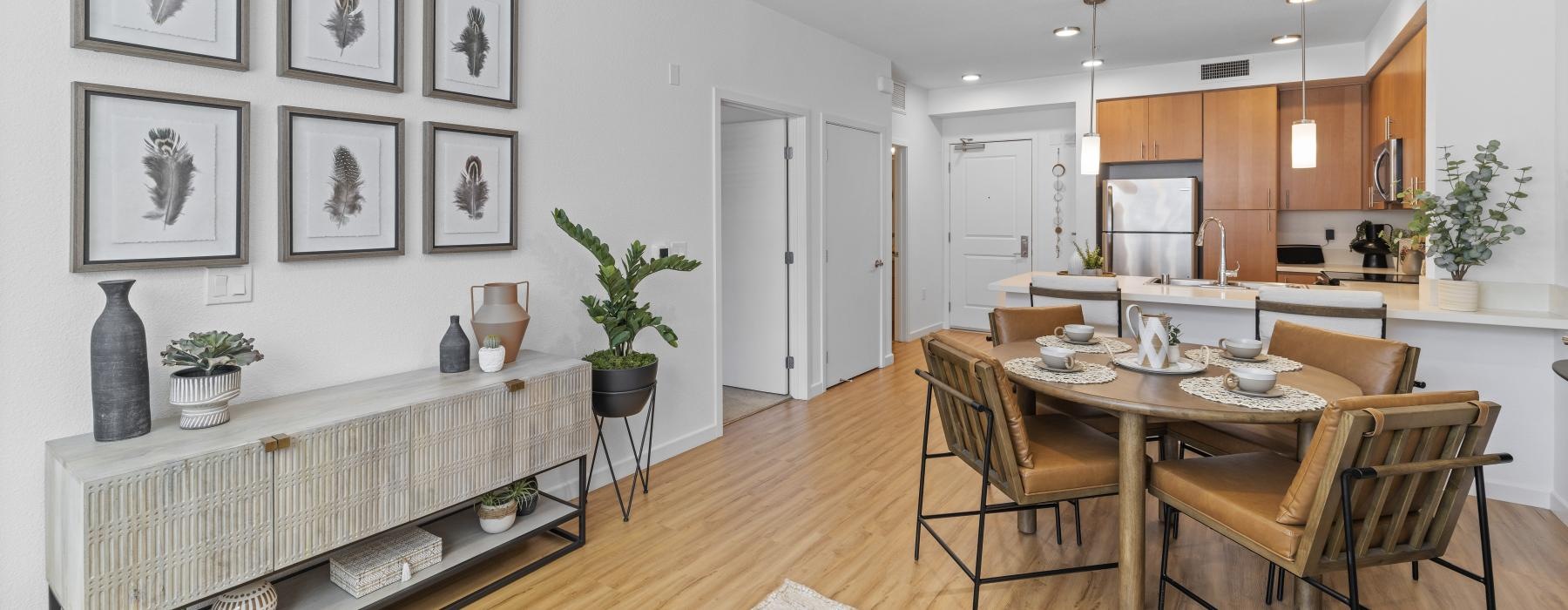 Modern kitchen with stainless steel appliances, sleek countertops, and ample cabinets, opening to a bright living area.