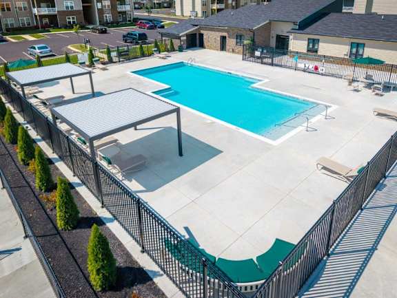 A large outdoor swimming pool surrounded by a black fence.