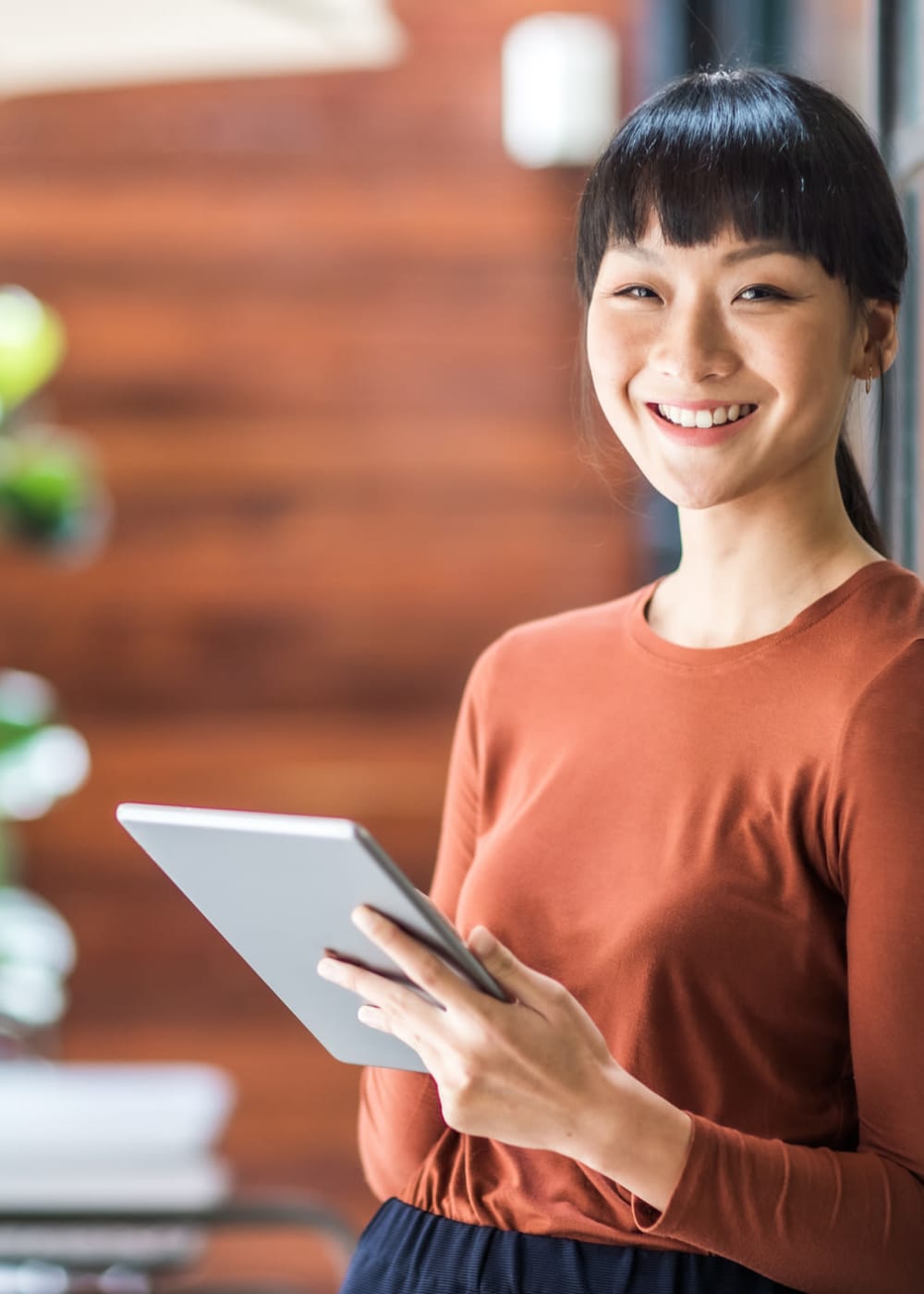 A woman holding a tablet at Mission Rock Residential in Denver, Colorado