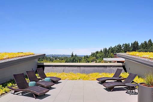 A patio with chairs and a roof garden. at Kirkland Crossing Apartments, Washington, 98033