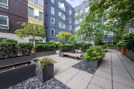A courtyard with a bench and potted plants at Kirkland Crossing Apartments, Kirkland, WA, 98033