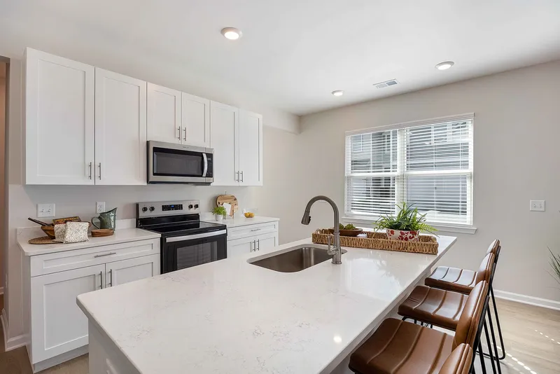 Kitchen with white cabinets, stainless steel appliances and large island