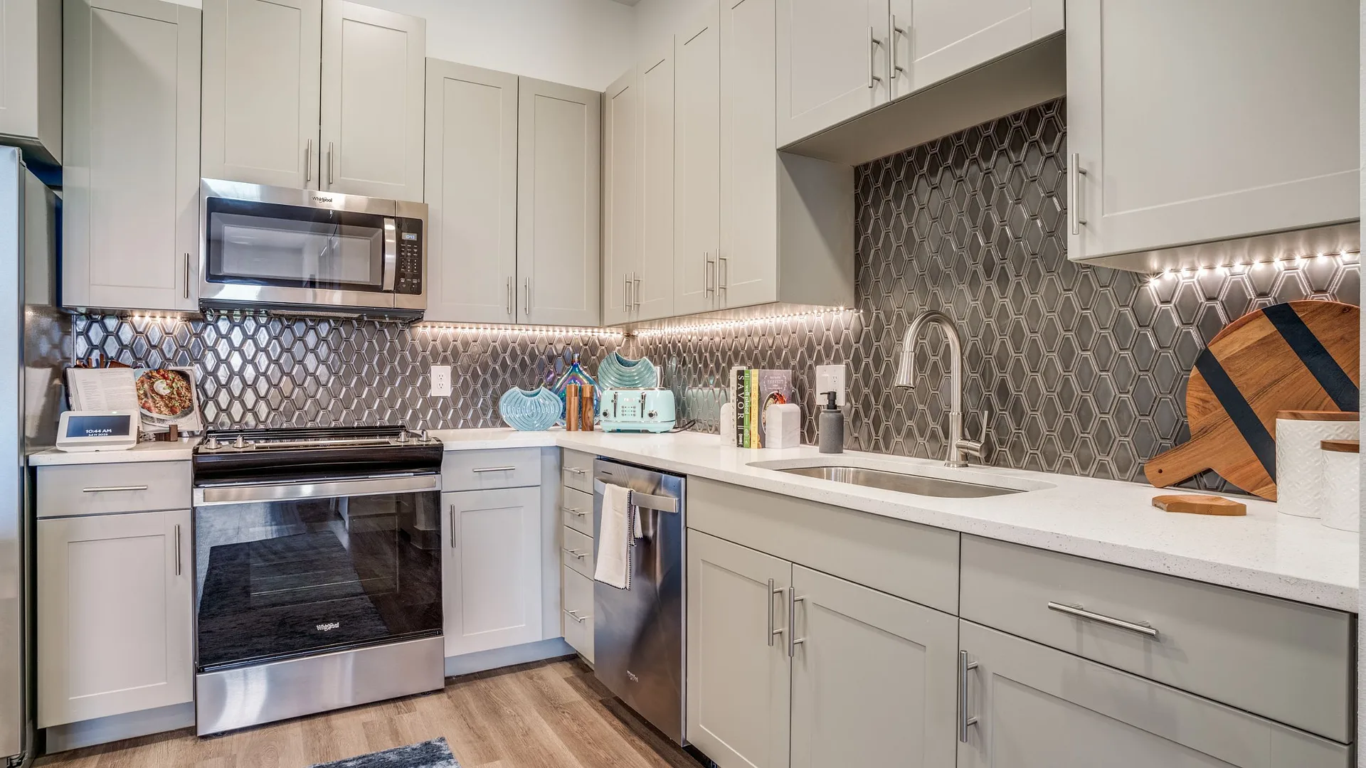 Modern kitchen with stainless steel appliances and stylish backsplash.