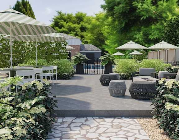 A garden with a pathway, white chairs, and umbrellas.