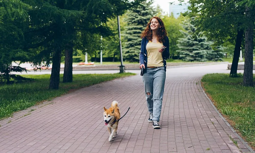 woman walking dog at park