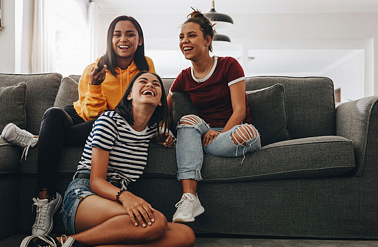 three girls sitting on a couch smiling