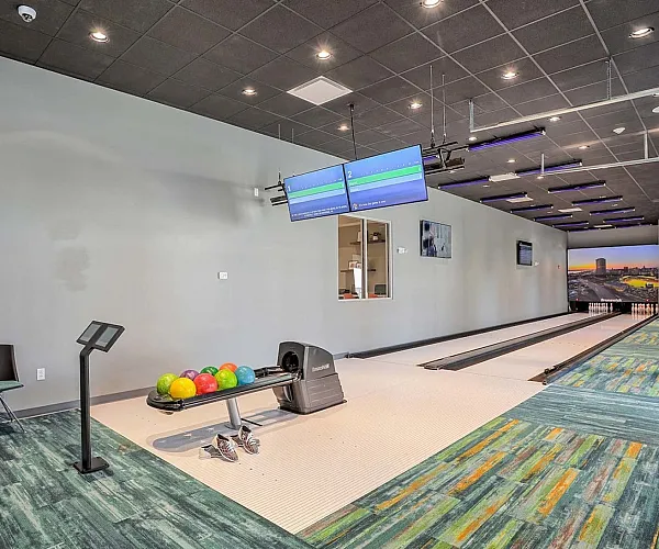 Modern indoor bowling alley with colorful bowling balls and comfortable seating, perfect for entertainment and relaxation.