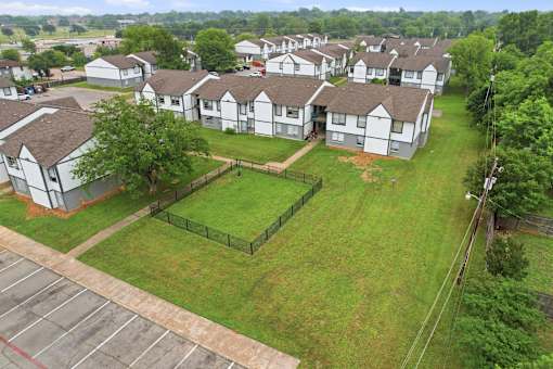 A large grassy area in front of apartment buildings.