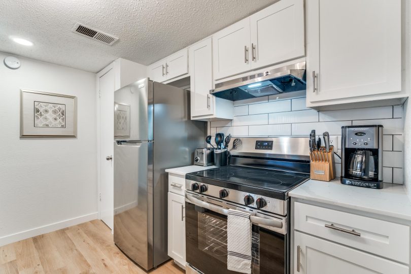 Modern kitchen featuring stainless steel appliances and white shaker cabinets.