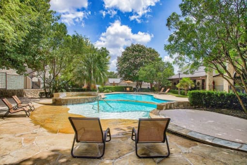 Mission oaks pool surrounded by trees and beach chairs
