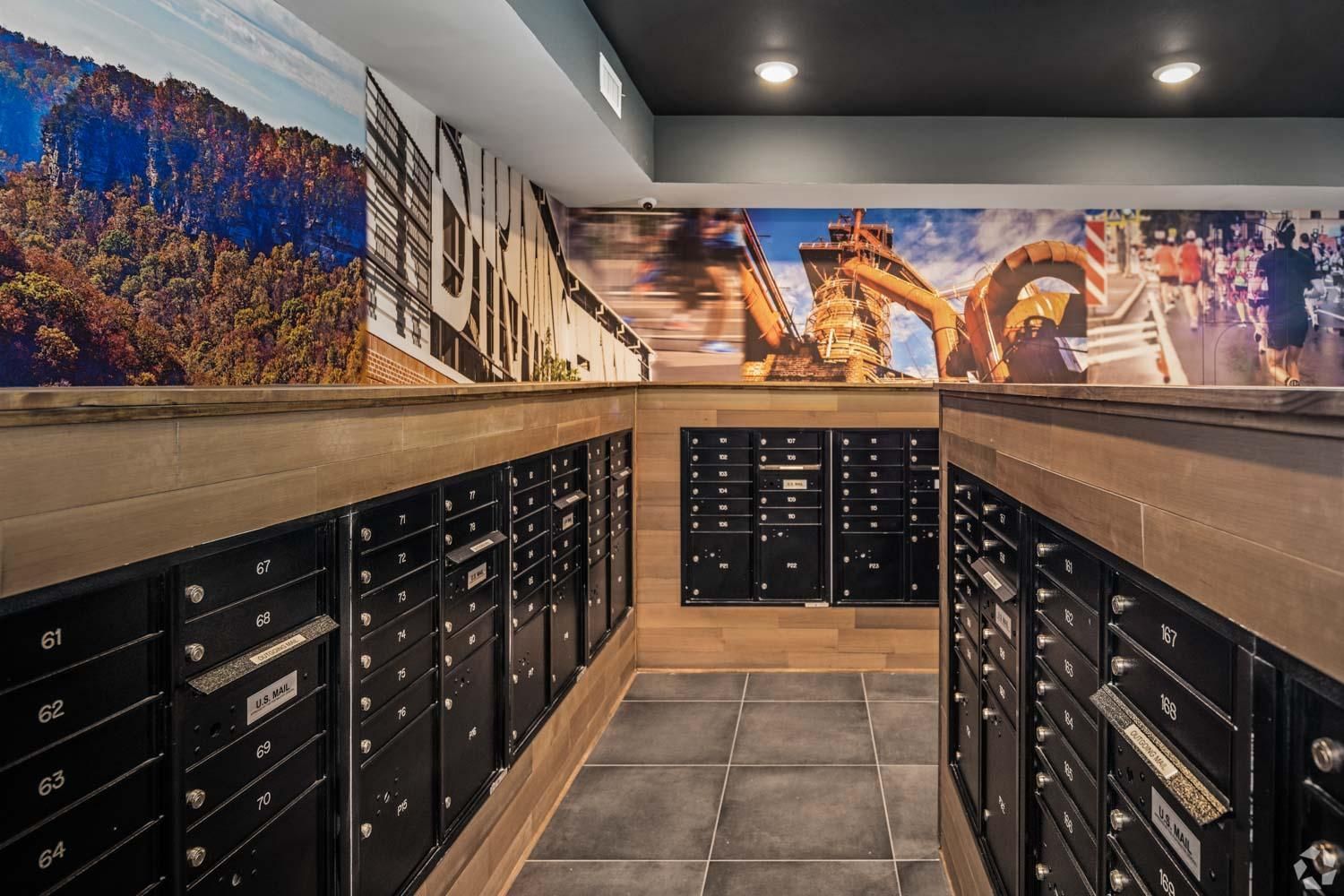A mail room with lots of mailboxes and a mural on the wall.