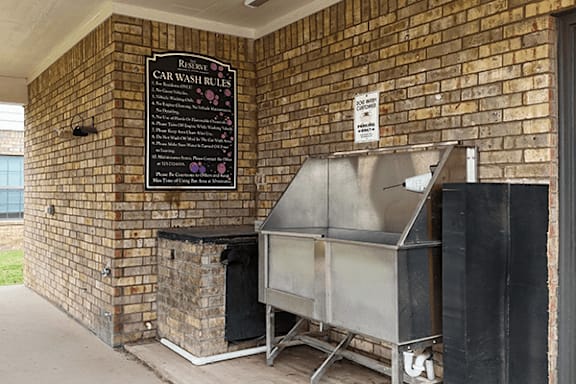 A sign on a brick wall that says Car Wash Rules.
