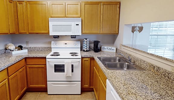 A kitchen with a white stove and wooden cabinets.