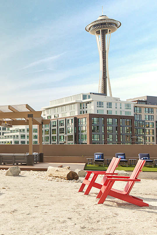 Beach chairs are arranged on a sandy beach at Skye at Belltown Apartments, Seattle, Washington