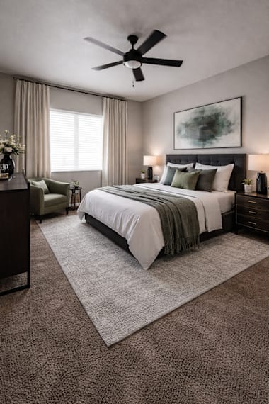 A bedroom with a large bed and a ceiling fan.