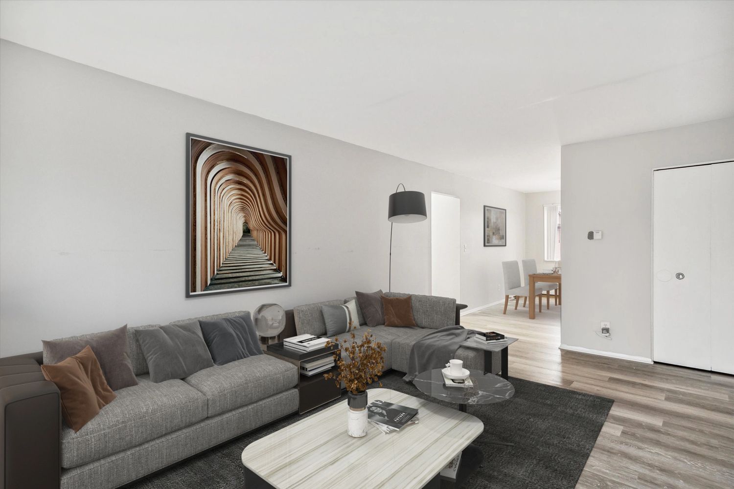 Modern living room with gray sofas, wooden flooring, and minimalist decor.