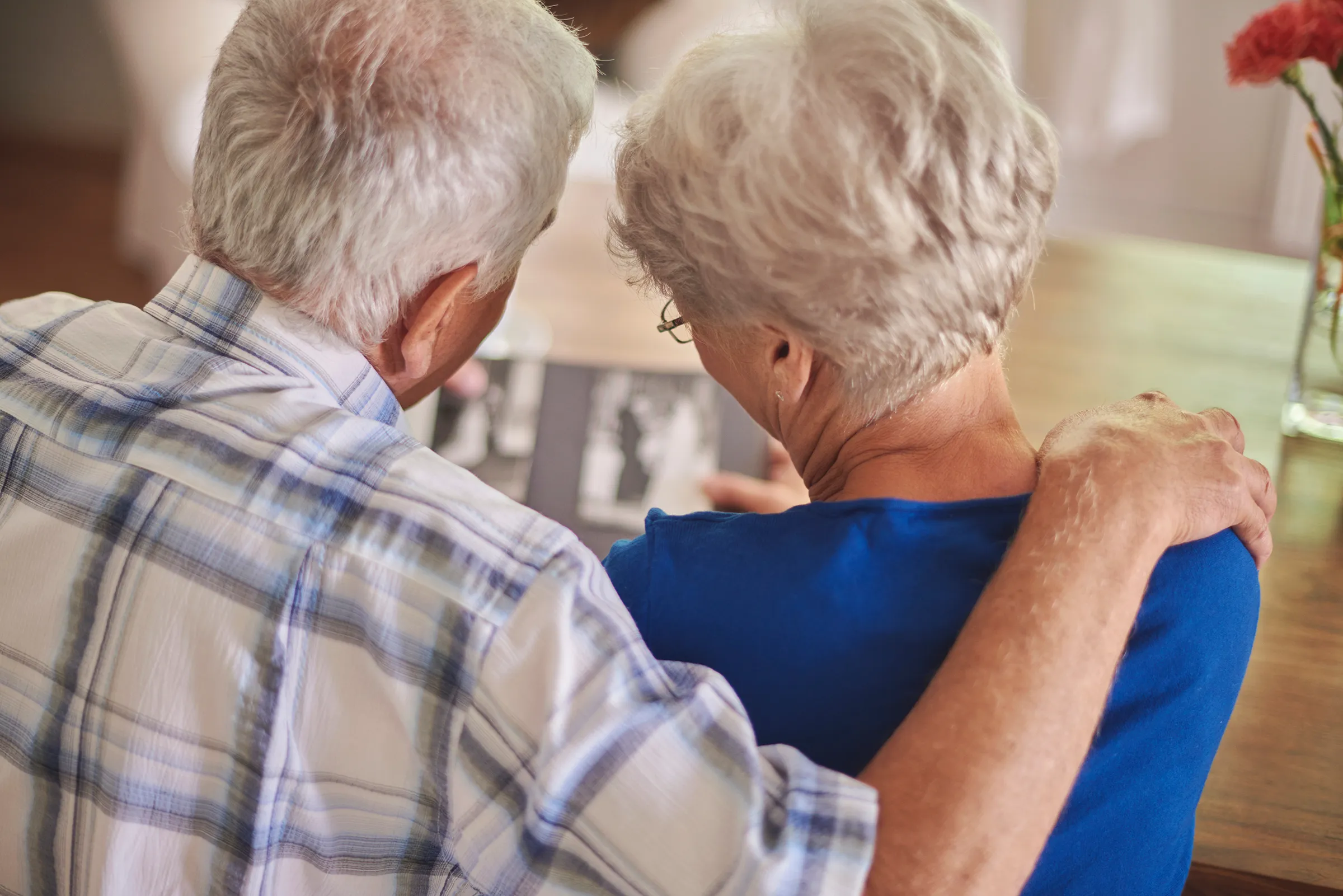 older couple embracing looking at photo album