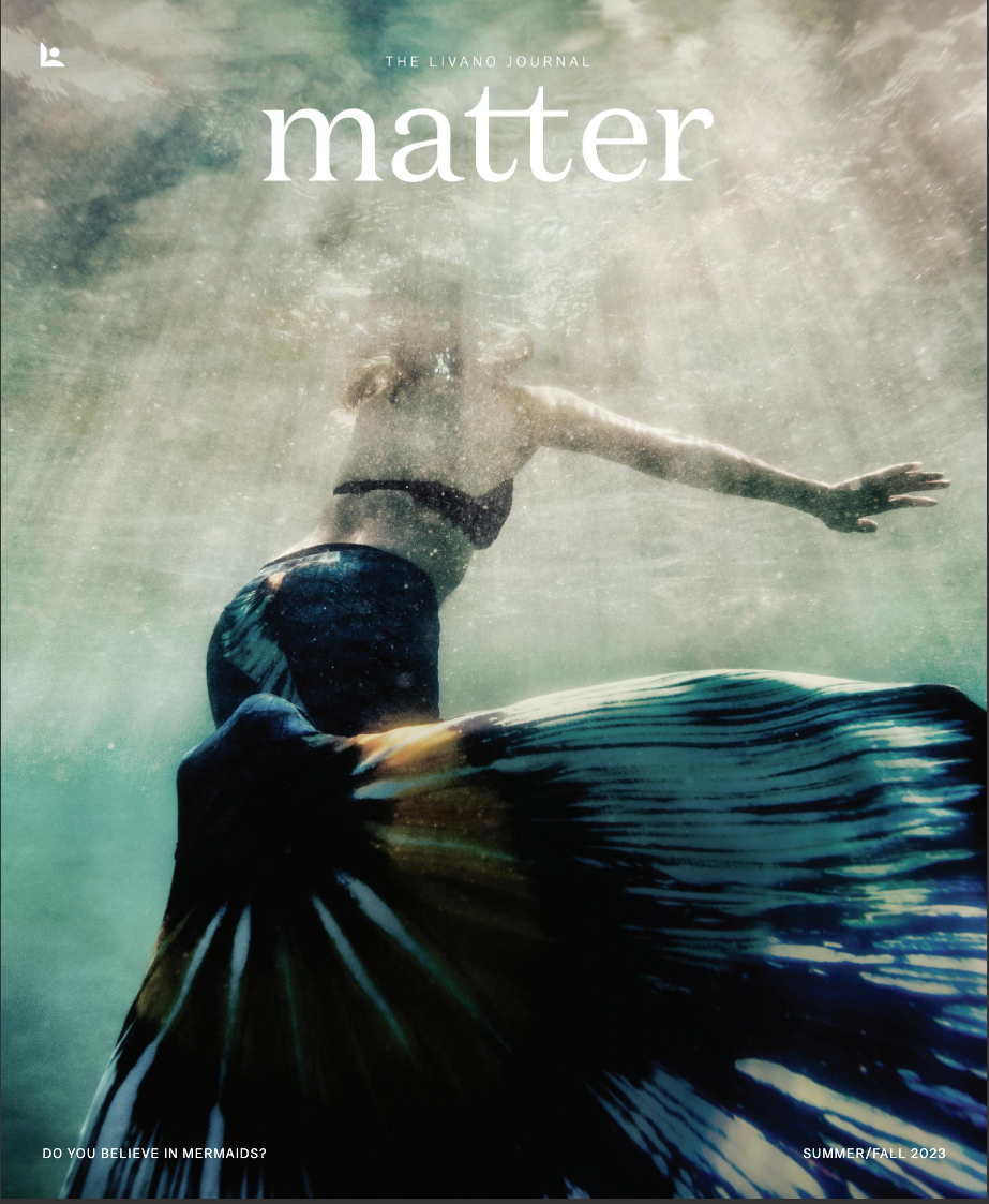 Mermaid underwater, dark teal tail, reaching up. 