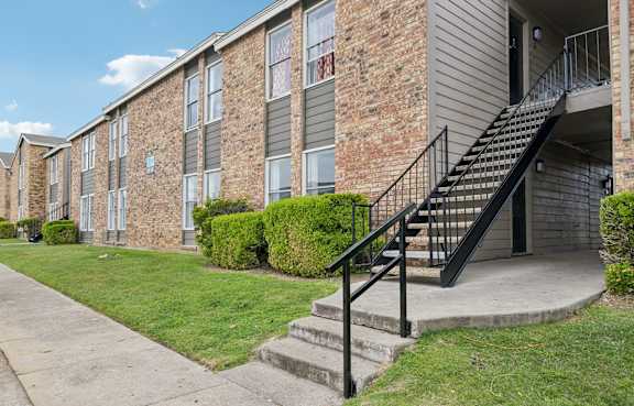 A brick building with a black metal staircase.