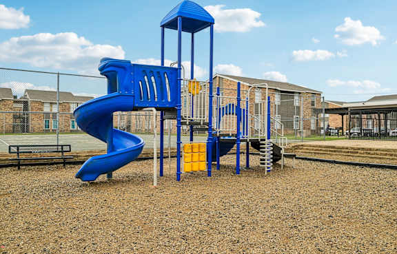 A playground with a blue slide and a yellow slide.