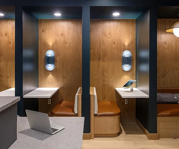 Modern co-working space with cozy wooden booths, built-in seating, and ambient lighting, perfect for productivity and relaxation.