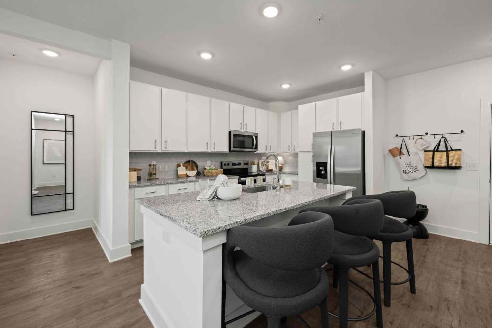 Kitchen with white cabinets and large island at The Maggie Flats in Jacksonville, Florida