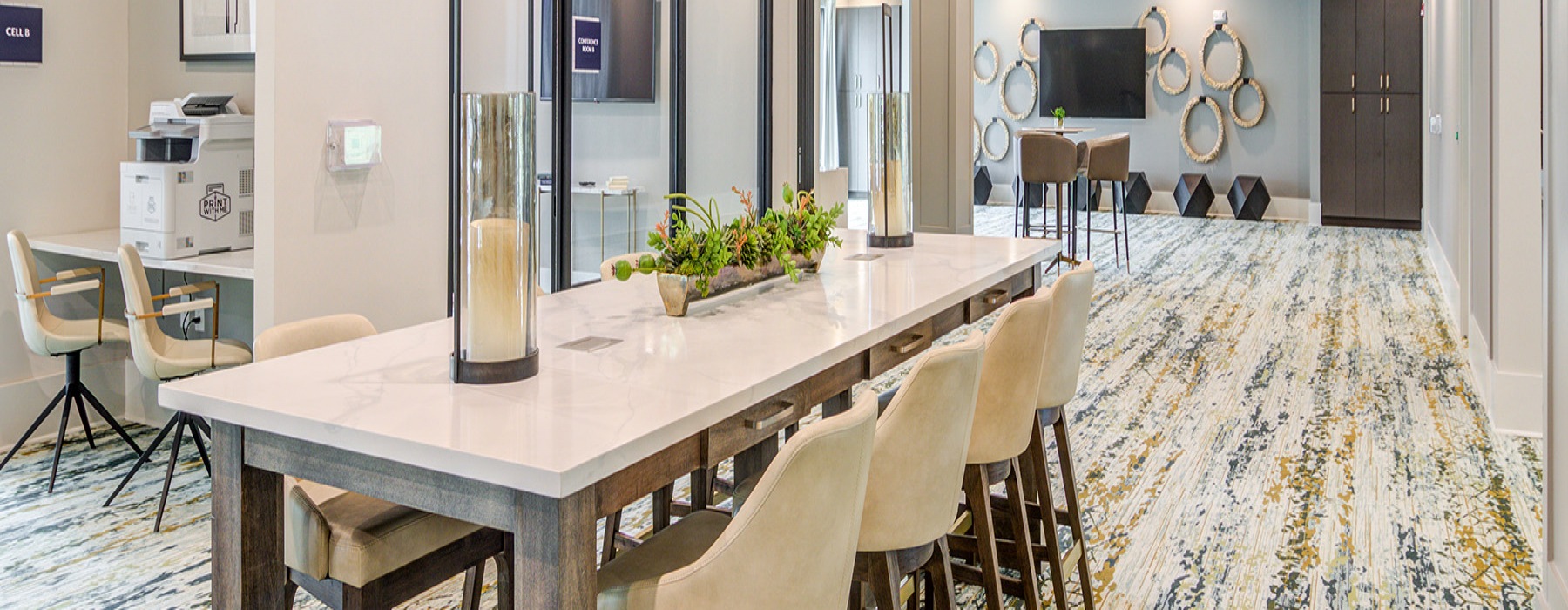Large well lit business center with long meeting tables