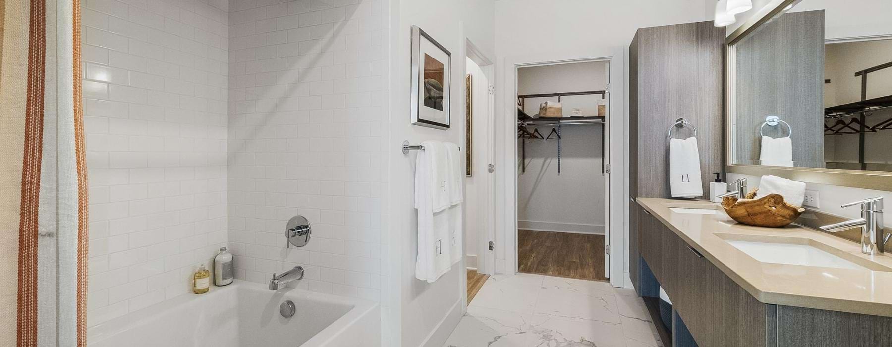 a bathroom with a tub, sink, and a mirror