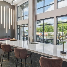 a room with a table chairs and a large window