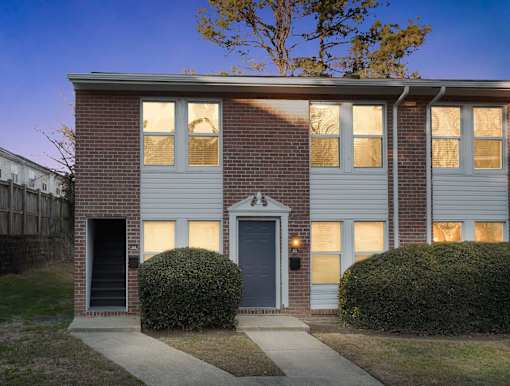A house with a grey front door and two windows on either side of it.