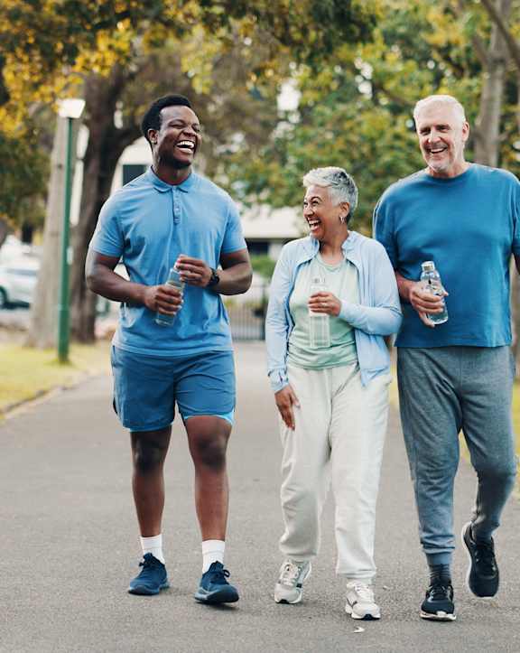 Four older people walking together on a path.