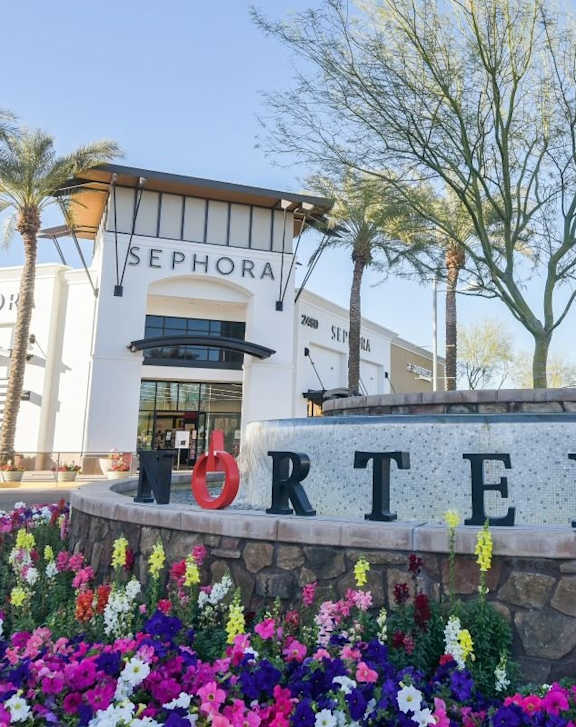 A sign that says NORTERRA in front of some flowers.