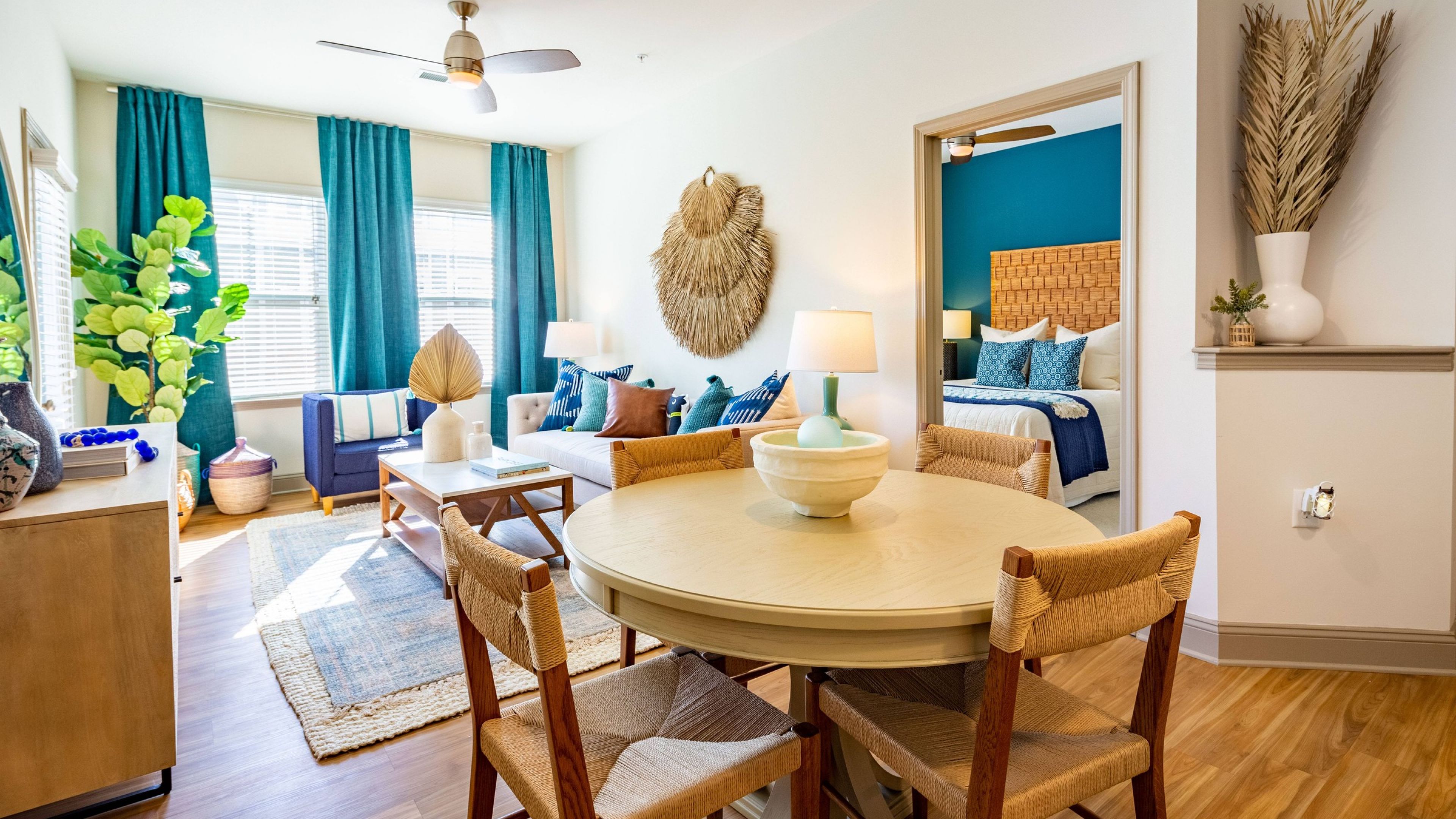 Hawthorne at the Station apartment living area with patio access, furnished with a couch, coffee table, and dining set