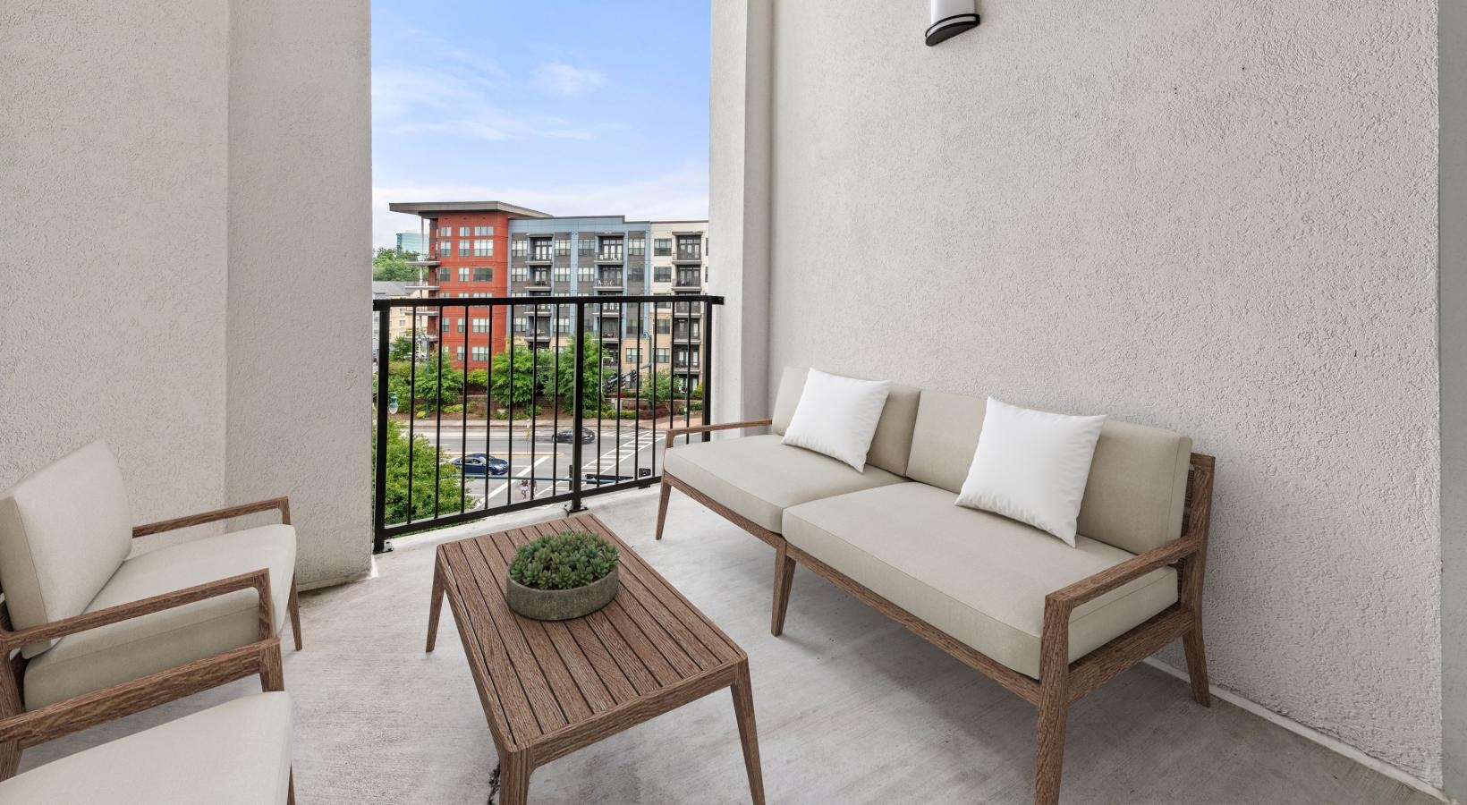 a balcony with a couch, chairs and a coffee table