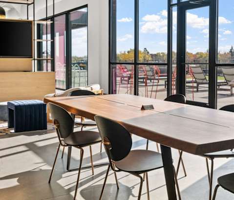 a conference room with a table and chairs and large windows