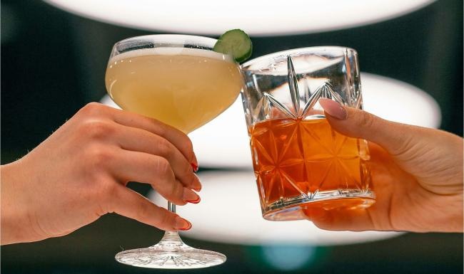 hands holding glasses with cocktails