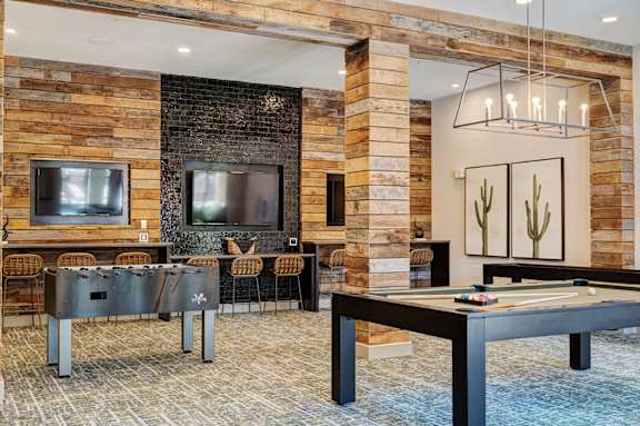 A modern living room with a pool table and a fireplace.
