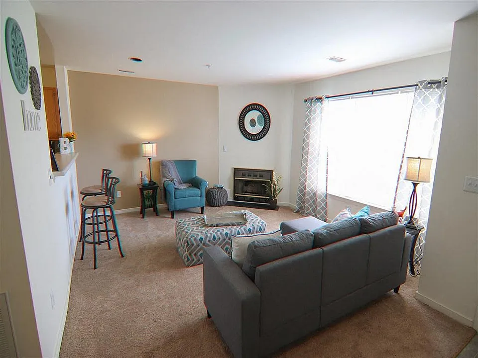 Bright and inviting living room with modern gray sofa, patterned curtains, and stylish decor.