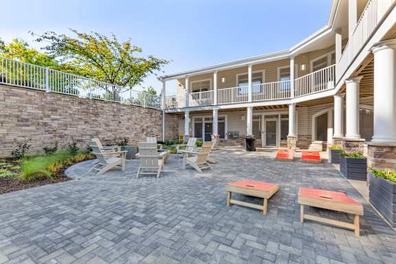 a patio with tables and chairs in front of a house at Copper and Quarry Village, Pikesville, MD