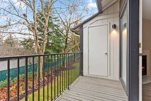 A balcony with a white door and a black railing.