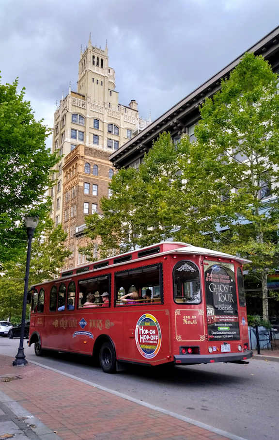 A red tour bus is parked on the side of a street.