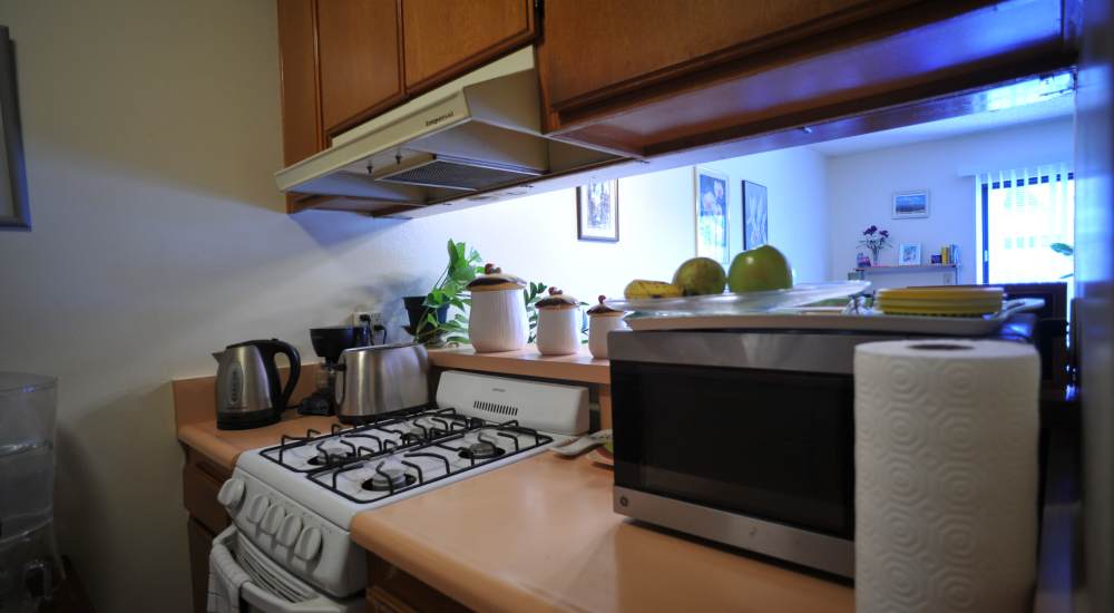 Fully equipped kitchen with natural wood cabinetry at Glendora Gardens in Glendora, California