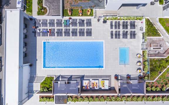 a birds eye view of the pool at a resort with umbrellas at The Elle Apartments in West Loop, Chicago, IL
