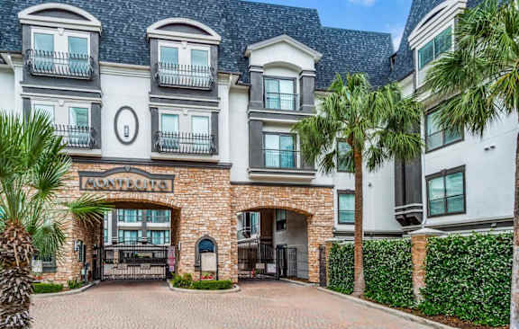 A large, luxurious building with a stone entrance and a sign that reads  at Montecito Apartments, Texas