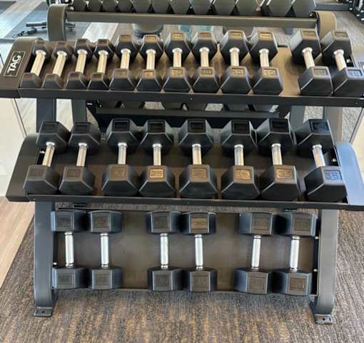 A set of dumbbells on a rack in a gym.